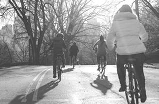 Varias personas en chaquetas conduciendo bicis en el parque
